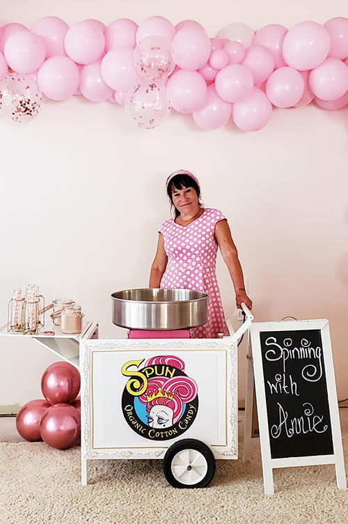 woman in pink dress with cotton candy cart