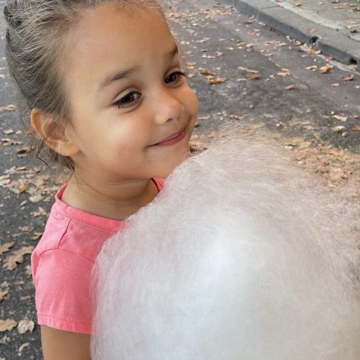 a young girl holding cotton candy
